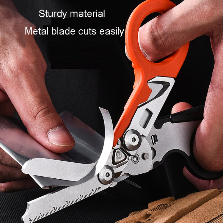 Close-up of foldable multitool scissors cutting with metal blades and a ruler scale