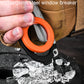 Orange ring-handled foldable tool in hand near broken glass on a bag