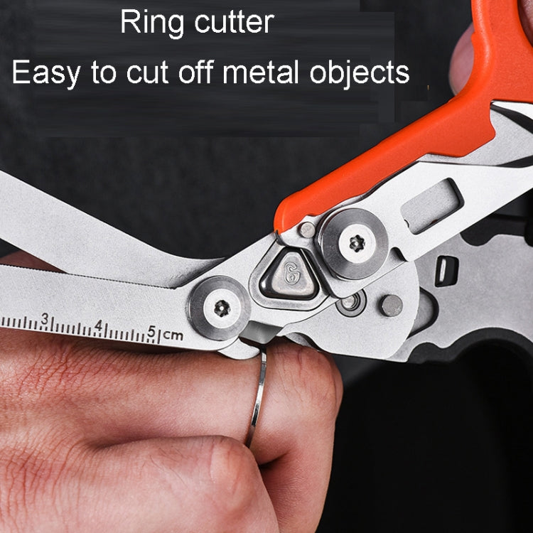 Close-up of orange-handled foldable scissors cutting along a small ruler scale