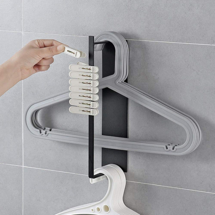 Wall-mounted metal rack with white hangers on a horizontal bar and side hooks