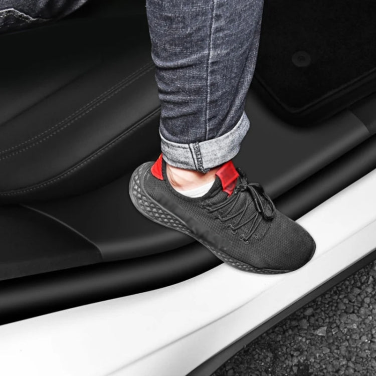 Black anti-kick door sill pad in use under a person’s shoe near door