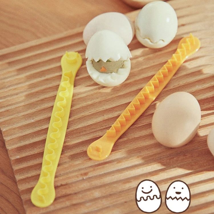 Lace egg cutter molds with wavy teeth, shown with halved boiled eggs