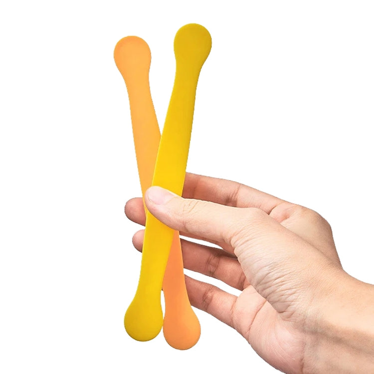 Set of two lace egg cutter molds in yellow and orange, held in hand