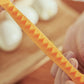 Orange lace egg cutter mold with triangular wave teeth, close-up
