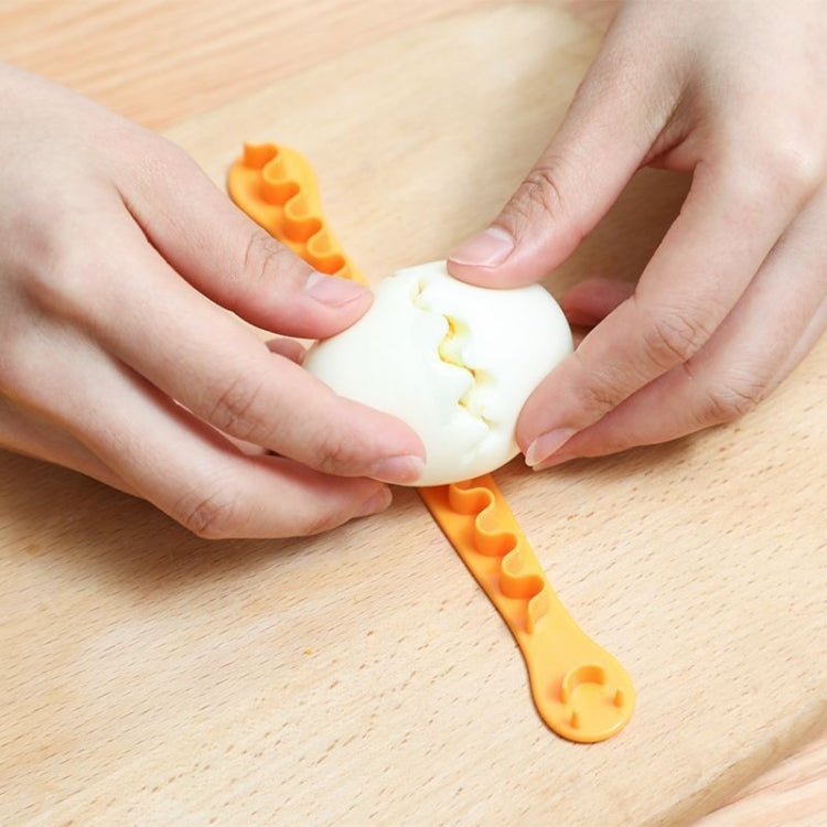 Hands fitting a halved egg onto an orange lace egg cutter mold