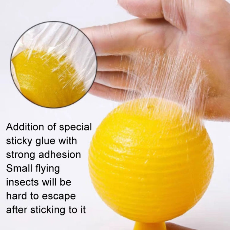 Yellow sticky insect trap ball with thick adhesive coating, hand holding it
