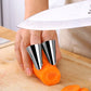 Stainless steel hand guards set covering fingers to hold a carrot for cutting