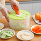Vegetable dehydrator basket with green lid and carrot grater insert, hands slicing