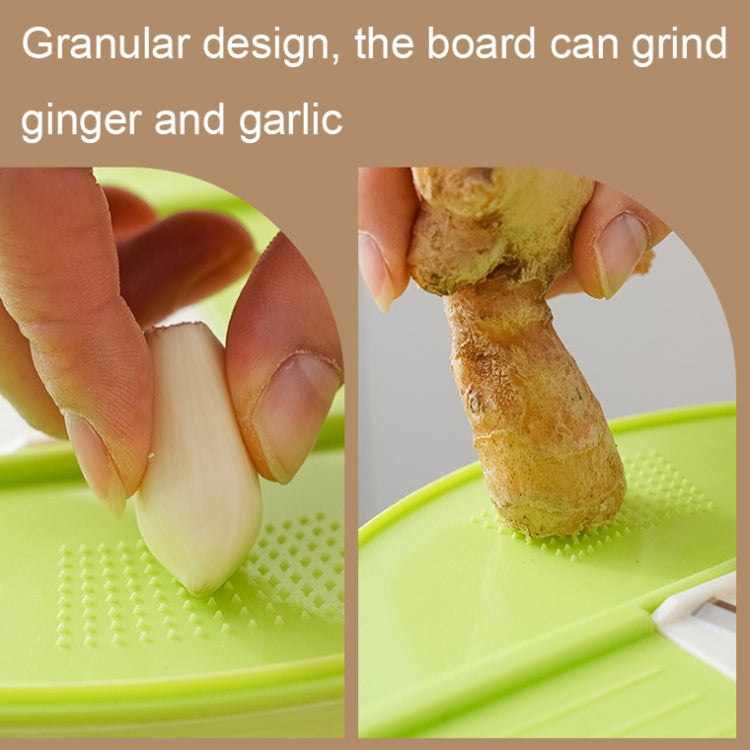 Green grater board with holes, showing ginger and garlic being ground