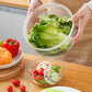 Mesh salad basket lifted with leafy greens above the dehydrator base