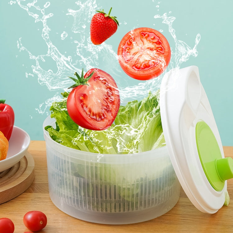 Vegetable dehydrator with open lid, splashing water over greens and sliced tomatoes