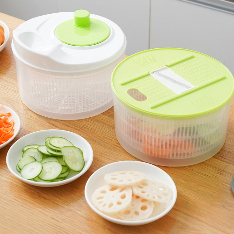 Two vegetable dehydrator baskets with green lids and grater insert, sliced vegetables