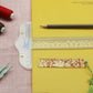 Clear plastic T-square ruler with visible centimeter scale and gold alignment pins