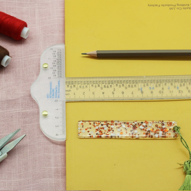 Clear plastic T-square ruler with visible centimeter scale and gold alignment pins