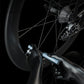 Mini bicycle pump in use at the valve on a bike wheel with a black nozzle