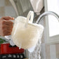 Plastic rice washer held under running water with side handle for rinsing rice