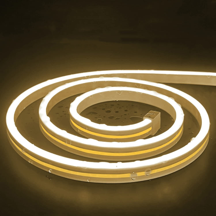 Warm white glowing flexible LED neon light strip coiled with USB connector.