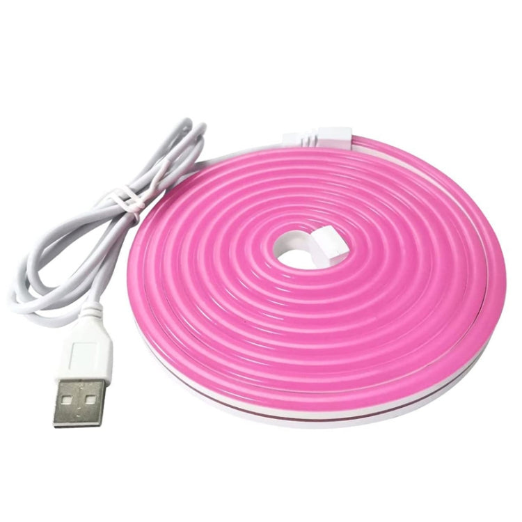 Pink flexible LED neon light strip roll with USB cable and connector, unlit.