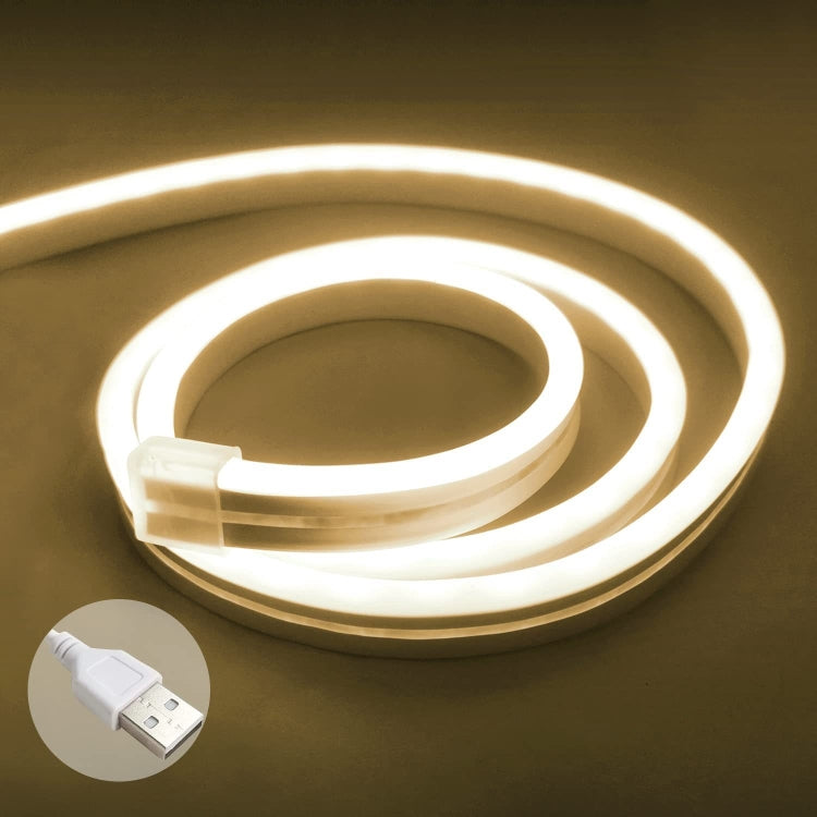 Warm white glowing flexible LED neon light strip coil with USB plug.
