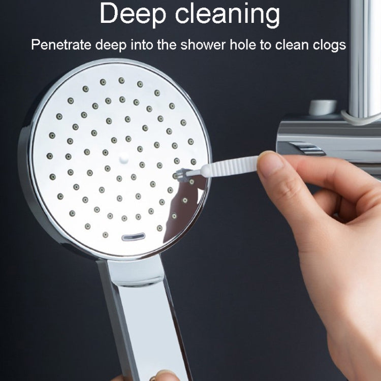 White shower hole cleaning brush being used to clean a showerhead spray plate