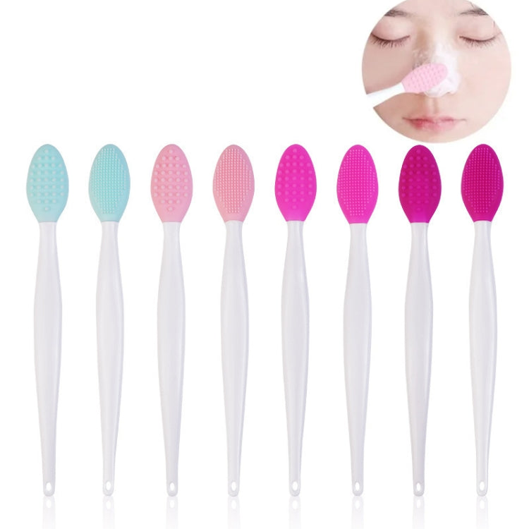 Double-sided silicone cleaning brush with light blue textured head on white handle