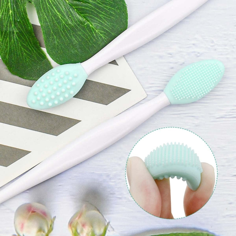 Silicone cleaning brush with mint-green textured head on white handle