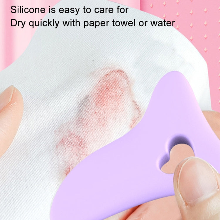 Purple silicone eyelash stencil cleaned on paper towel with heart-shaped cutout