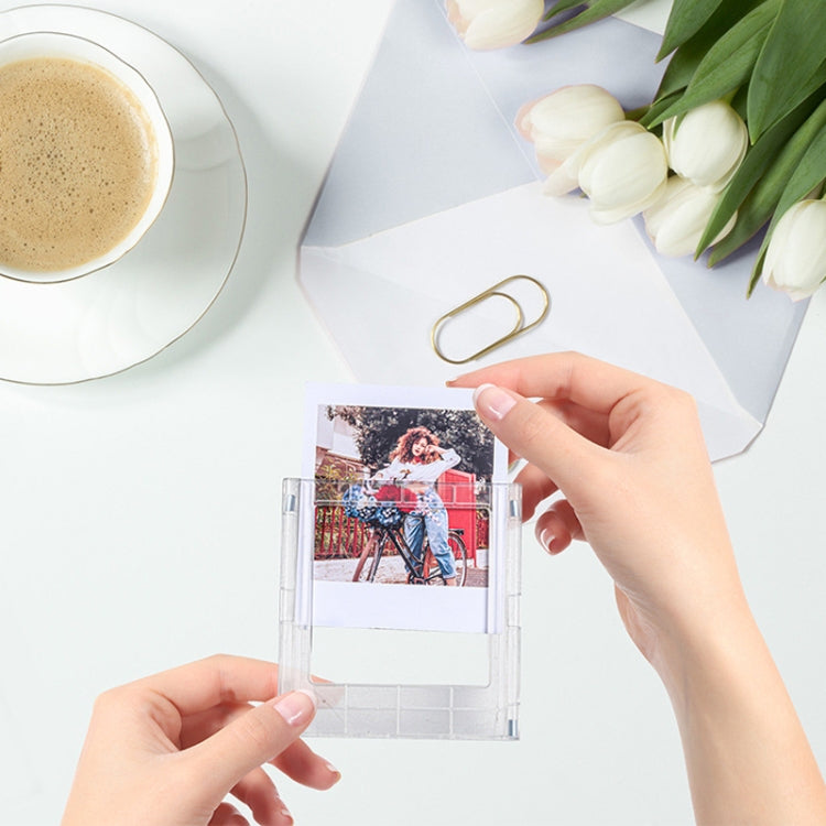 Hand inserting a photo into a clear square magnetic photo frame block