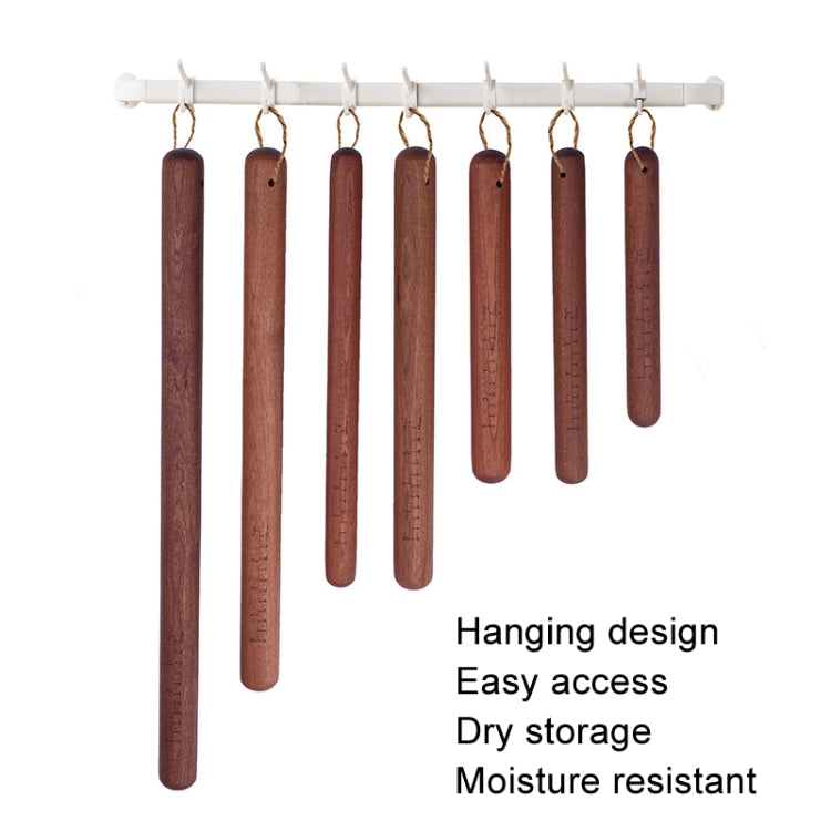 Hanging wooden rolling pins with engraved scales on a wall bar