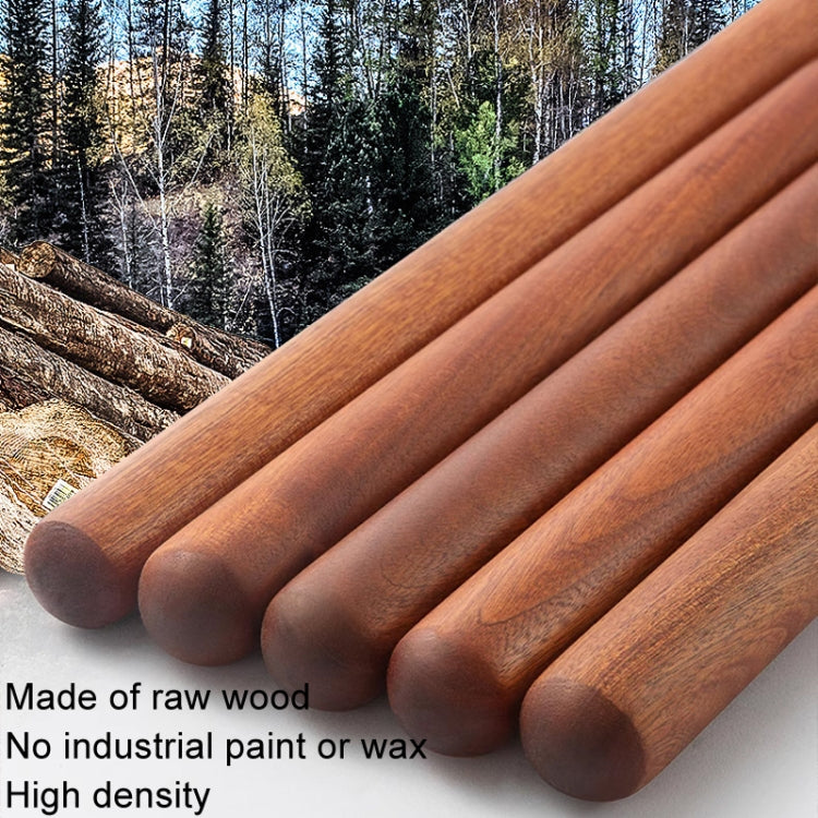 Red wooden rolling pin, made of raw wood with smooth cylindrical body