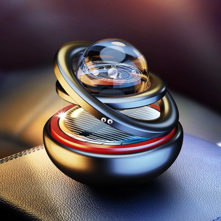 Car aromatherapy rotating solar ornament with clear globe, dark base, and gold trim
