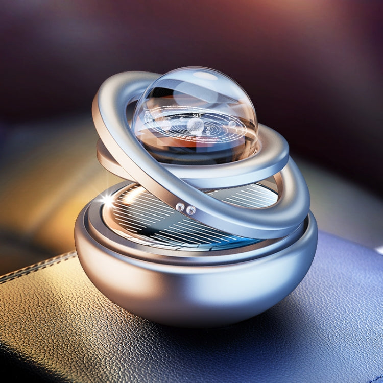 Car aromatherapy rotating solar ornament with clear globe, light blue base, and silver trim