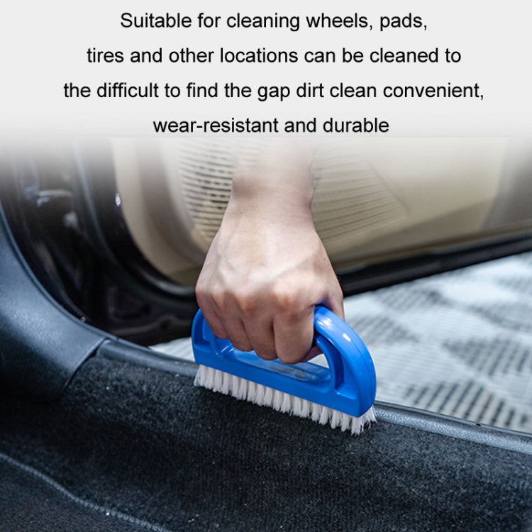 Blue D-shaped brush with white bristles cleaning a dark textured car edge