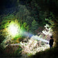 Outdoor flashlight shining a bright long-distance beam in a forest