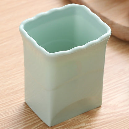 Light green vegetable slicing cup tool with scalloped rim and open top