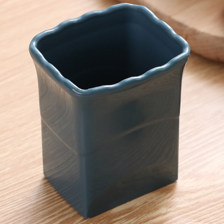 Dark blue vegetable slicing cup tool with scalloped rim and open top