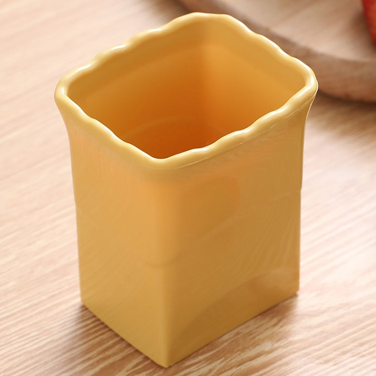 Yellow vegetable slicing cup tool with scalloped rim and open top
