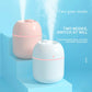 Two compact USB humidifiers, pink and white, with mist outlet openings on top