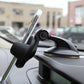 Black dashboard phone holder attached to car dashboard near windshield
