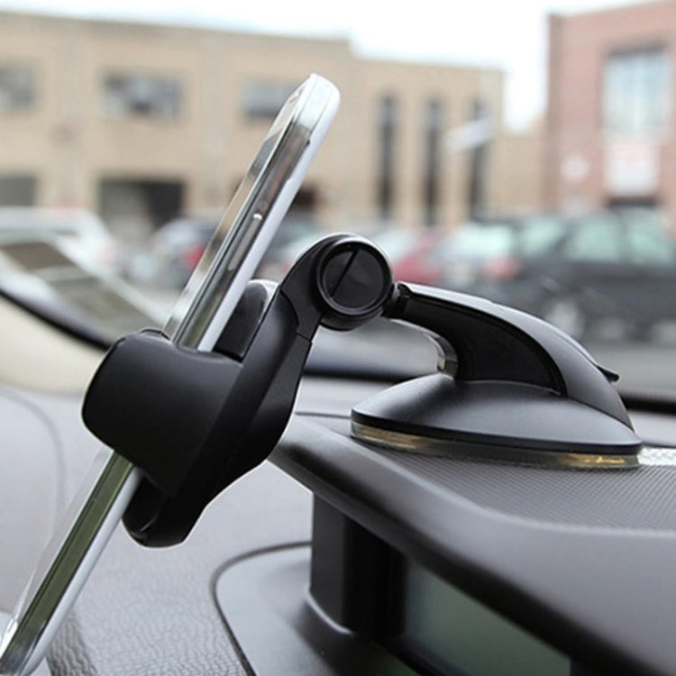 Black dashboard phone holder attached to car dashboard near windshield