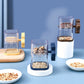 Manual nut chopper grinder with clear cup and blue, yellow, and brown handles