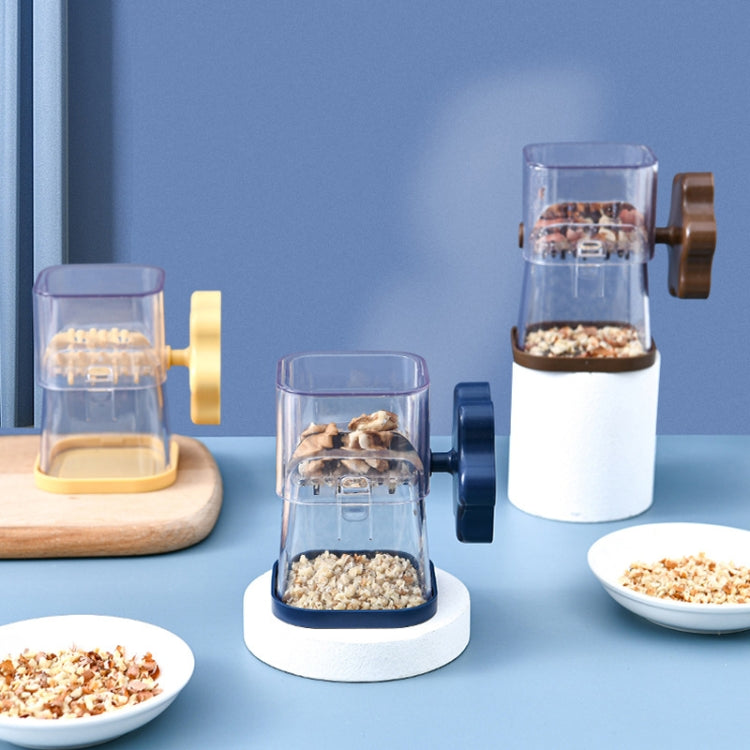 Manual nut chopper grinder with clear cup and blue, yellow, and brown handles