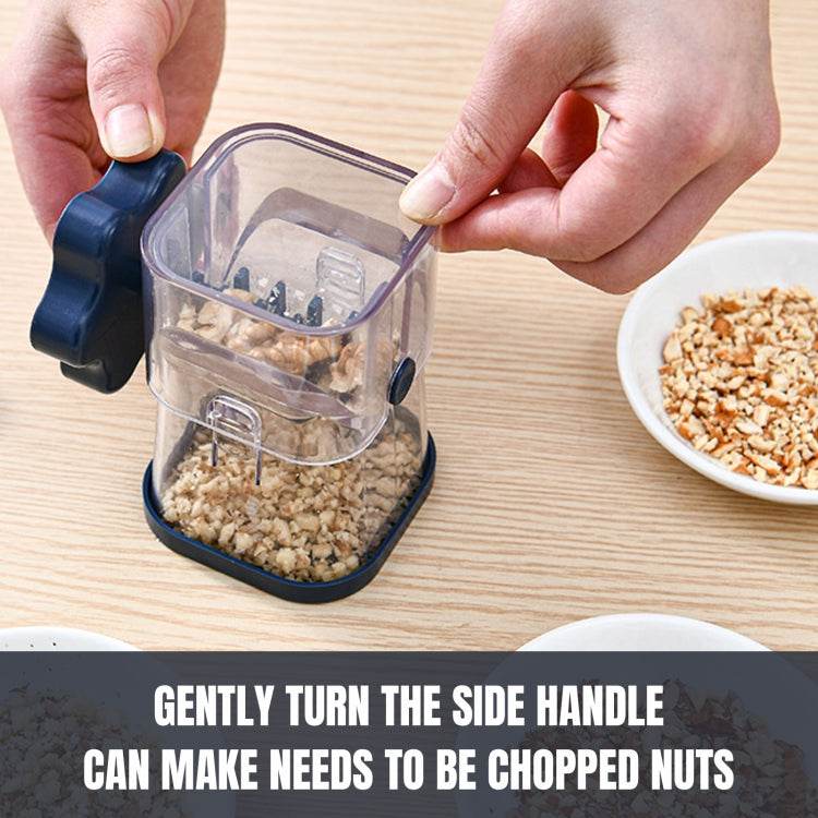 Manual nut crusher chopper in clear cup with navy handle, held by hands