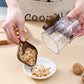 Manual nut crusher chopper with clear cup and brown handle over a bowl
