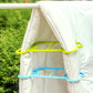 Green plastic quilt clip securing white duvet to a drying rack bar