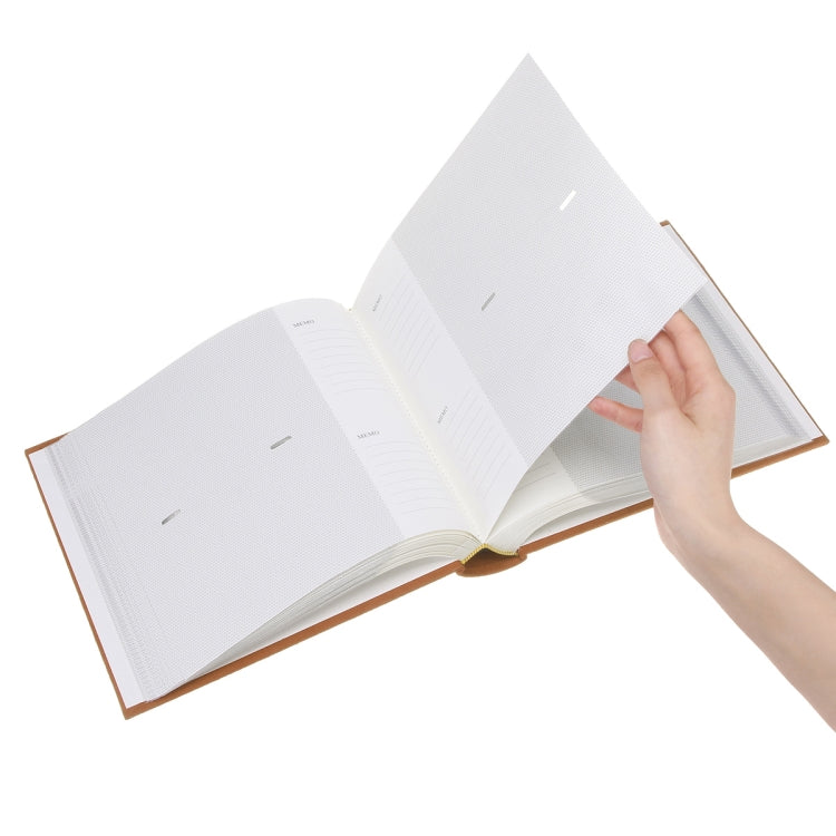 Open photo album insert book with white lined pages, hand holding a page