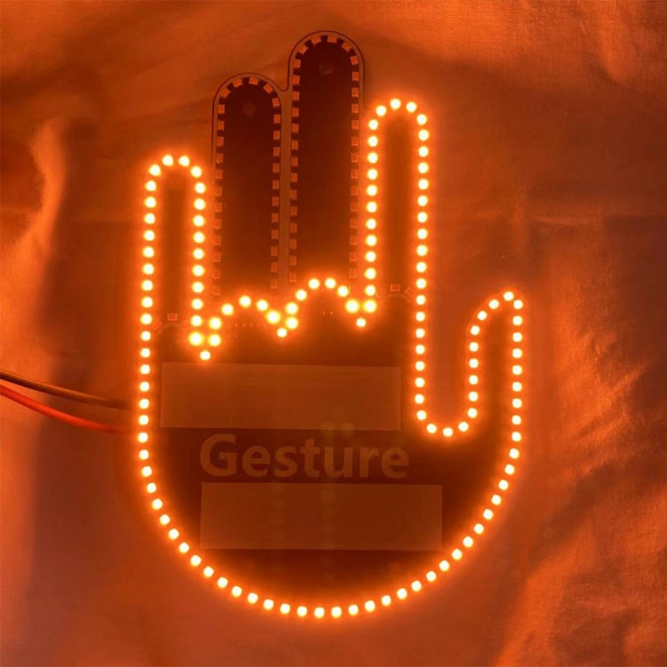 Glowing amber LED hand-gesture warning light with dotted outline on fabric