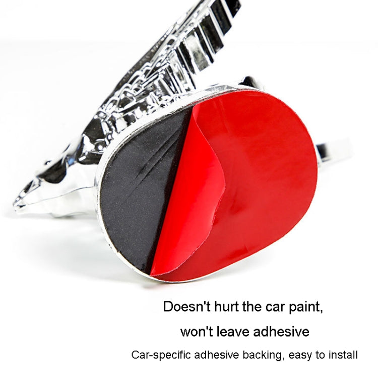 Chrome eagle wing hood ornament with red adhesive backing cover, close-up