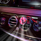 Car air vent fragrance diffuser with spinning vinyl-style ornament clipped to vent