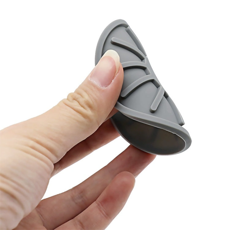Gray car anti-slip silicone coaster held in hand, round with grip texture